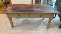 Full view of table showing stained top, painted base, drawers