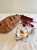 Overall lot: glove, baseball, red trailer, red implement, boxed puzzle, ceramic cow bank