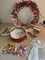 Overview of all items on surface including wreath, tins, angel topper, bird ornaments, cards and figurine