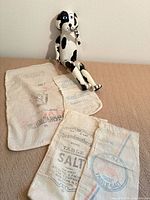 Overall view of jointed wooden dog with three printed cotton sacks