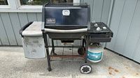 Front view of Weber Genesis Silver propane grill with propane tank attached
