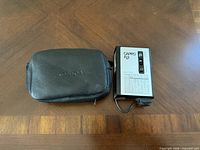 Capro FL3 flash unit beside Konica case on tabletop