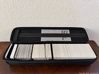 Open zip case showing three sections of stacked Cards Against Humanity cards