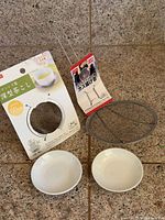 All items laid out: packaged tea strainer, mesh skimmer, two saucers