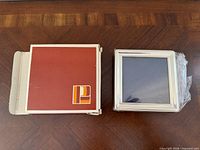 frame beside original red box on wood surface