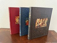 Three hardbound The New Wonder World volumes standing, showing colours and cover art