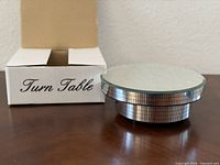 Turntable next to open box showing mirrored side tiles and top mirror