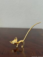 Full view of brass cat figurine standing on surface