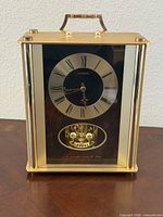Front view of Citizen quartz mantel clock showing dial and pendulum