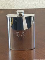 Front view flask standing, showing monogram and cap