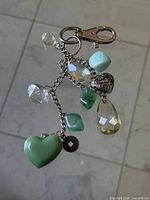 Full view of keychain showing lobster clasp and assortment of dangling charms on silver-tone chain