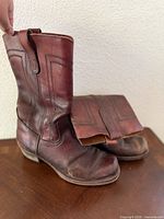 pair of brown leather boots side view on table