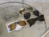 Group shot of all five eyewear pieces on glass table