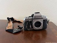 Front view of Ricoh TLS 401 camera body without lens, strap attached