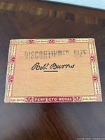 Closed Robert Burns Perfecto Royal cigar box labeled Discontinued Size
