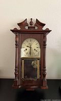 Full view of Wentworth wall clock showing wooden case, dial, lower glass panel with pendulum