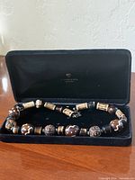 Full view of bead necklace arranged inside velvet case
