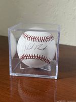 Autographed baseball front view in acrylic cube showing signature