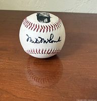 Overall view of signed baseball showing portrait decal and full signature