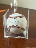 Phil Rizzuto autograph visible on baseball within half acrylic holder