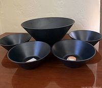 Five black bowls displayed, showing size comparison