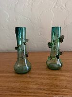 Front view of both green glass bud vases