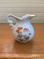 Front view showing floral and butterfly decals, gold trim, overall shape