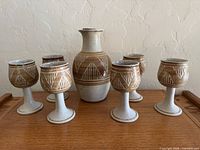 Front view of vase and six goblets on wood surface