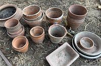 All terra-cotta planters, saucers and tray laid out on ground