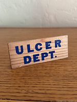 Front view showing ULCER DEPT. text on wooden sign