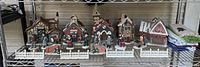 Front view of entire ceramic Christmas village set displayed on shelf