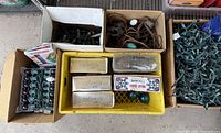 Overall view of assorted boxes and crates containing Christmas lights, ornaments and décor