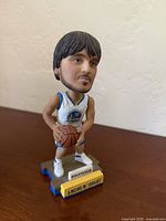 Front view of Andrew Bogut bobblehead with basketball and Warriors logo base