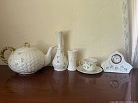 Group shot of all seven Belleek porcelain pieces displayed on tabletop