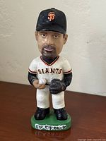 Front view of Rich Aurilia bobblehead showing full figure, uniform, cap, and The Chronicle base