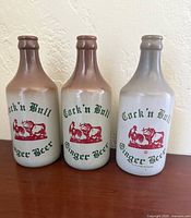 Front view of three glazed Cock 'n Bull bottles with graphics