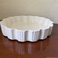 Top view of creamy white scalloped tart dish