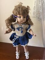Full front view of doll standing on surface showing complete outfit and shoes