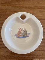 Top view of white ceramic warming dish showing cat graphic and fill hole