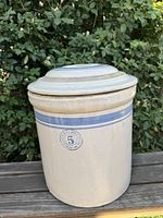 Front view of crock with lid showing blue stripes and stamped Garden City Pottery No.5 logo