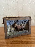 Front view of carved wooden relief showing donkey figure and frame