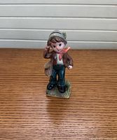 Front view of porcelain boy figurine on wood surface