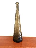 Full view of tall crinkle glass decanter standing upright