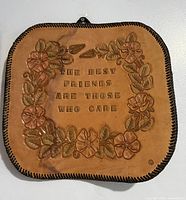 Front view showing embossed floral design and quote on leather plaque