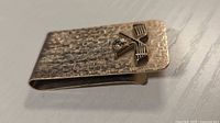 Full view of money clip showing texture and golf emblem