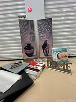 Full lot overview showing framed prints, decor, mattress protector, office items