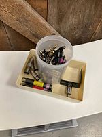 Tray holding plastic container filled with assorted audio adapters, XLR extenders and Shure barrels visible
