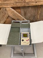 Open carrying case showing interior foam compartments and Game Boy console placement