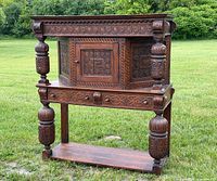 Front angled view showing carved panels, drawers, turned supports, lower shelf