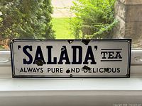 Full front view of sign on windowsill displaying complete text and overall condition